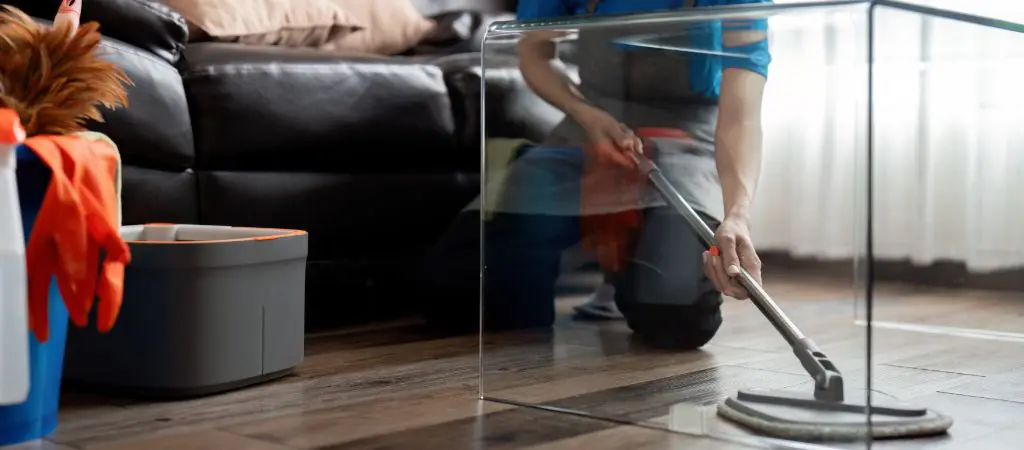 Housekeeper cleaning hardwood floors of vacation rental 